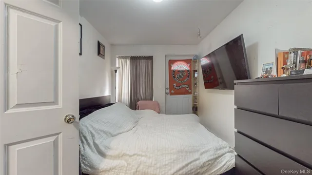 a bedroom with a bed and a refrigerator