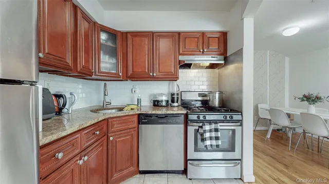 a kitchen with stainless steel appliances granite countertop a stove and cabinets