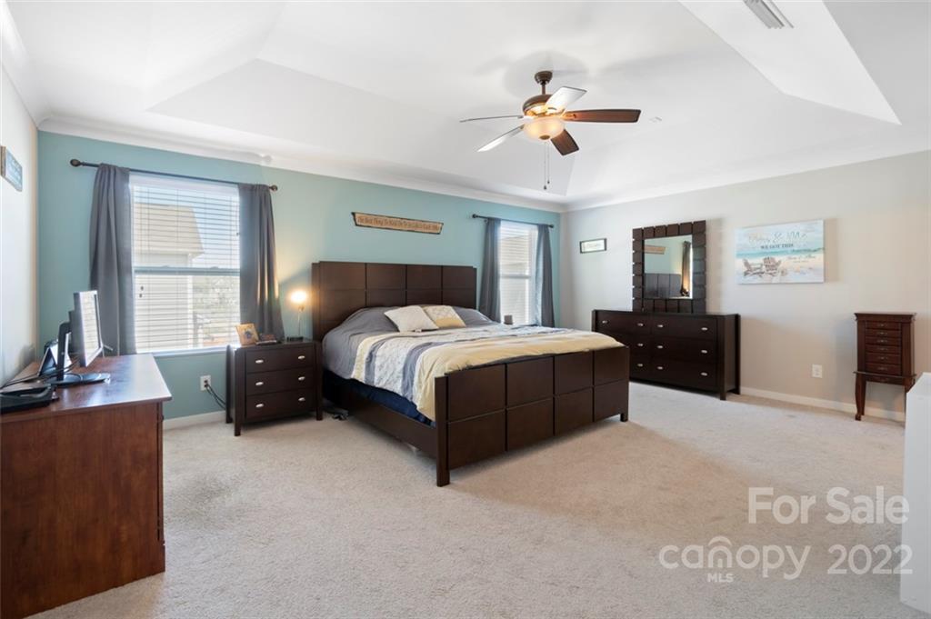 8218 Midas Lane Locust, NC 28097 - Photo 13 of 34 a bedroom with a bed and a chandelier