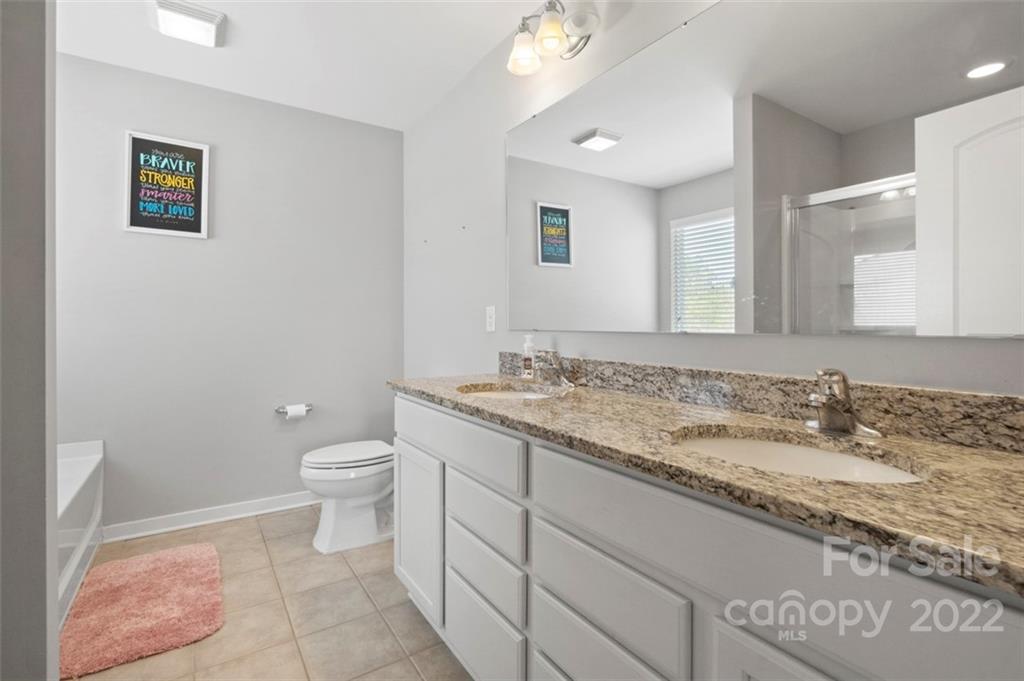 8218 Midas Lane Locust, NC 28097 - Photo 15 of 34 a bathroom with a granite countertop sink and a mirror