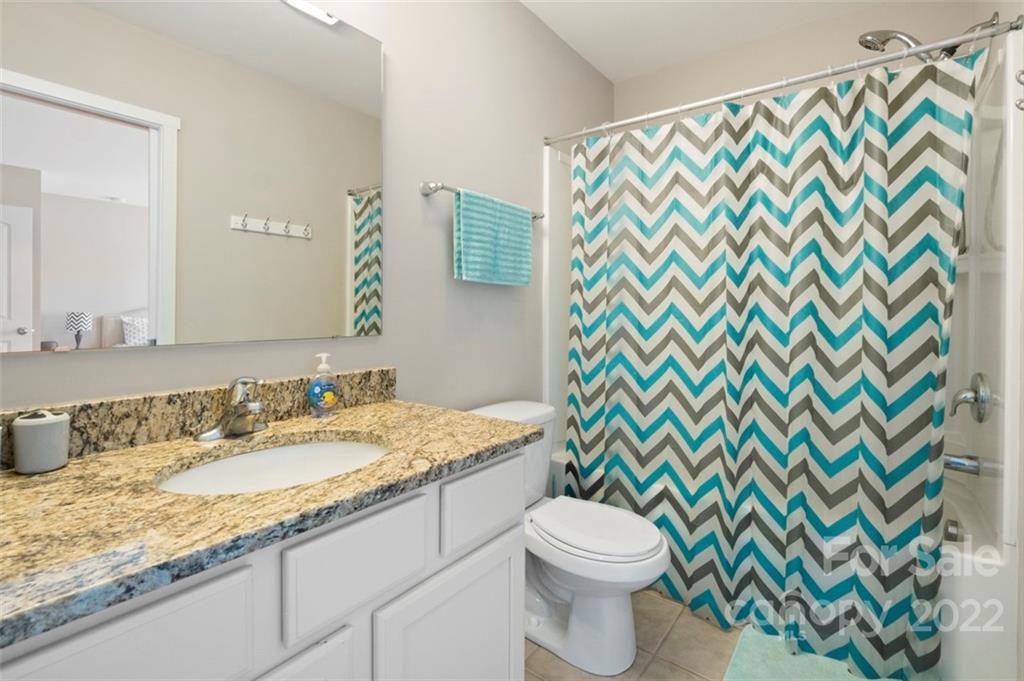 8218 Midas Lane Locust, NC 28097 - Photo 20 of 34 a bathroom with a granite countertop sink a toilet and a mirror