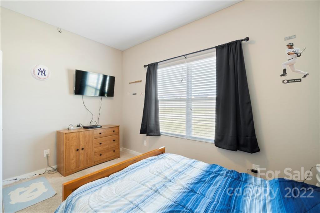 8218 Midas Lane Locust, NC 28097 - Photo 25 of 34 a bedroom with a bed and flat screen tv