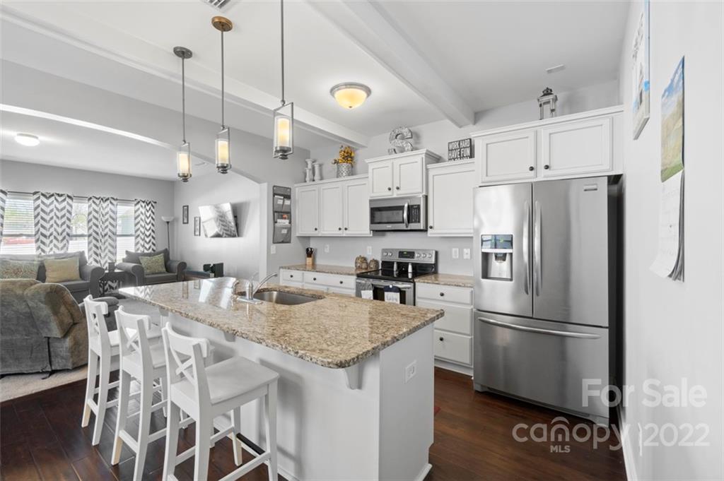 8218 Midas Lane Locust, NC 28097 - Photo 5 of 34 a kitchen with stainless steel appliances granite countertop a refrigerator a sink a stove a dining table and chairs