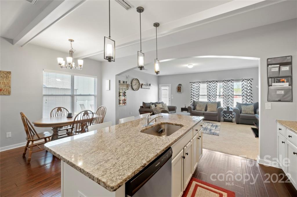 8218 Midas Lane Locust, NC 28097 - Photo 6 of 34 a kitchen with a stove a kitchen island a dining table and chairs