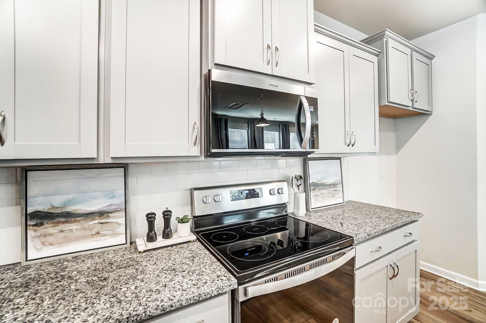 311 Laura Elizabeth Lane Clover, SC 29710 - Photo 12 of 39 a kitchen with granite countertop a stove a microwave and cabinets
