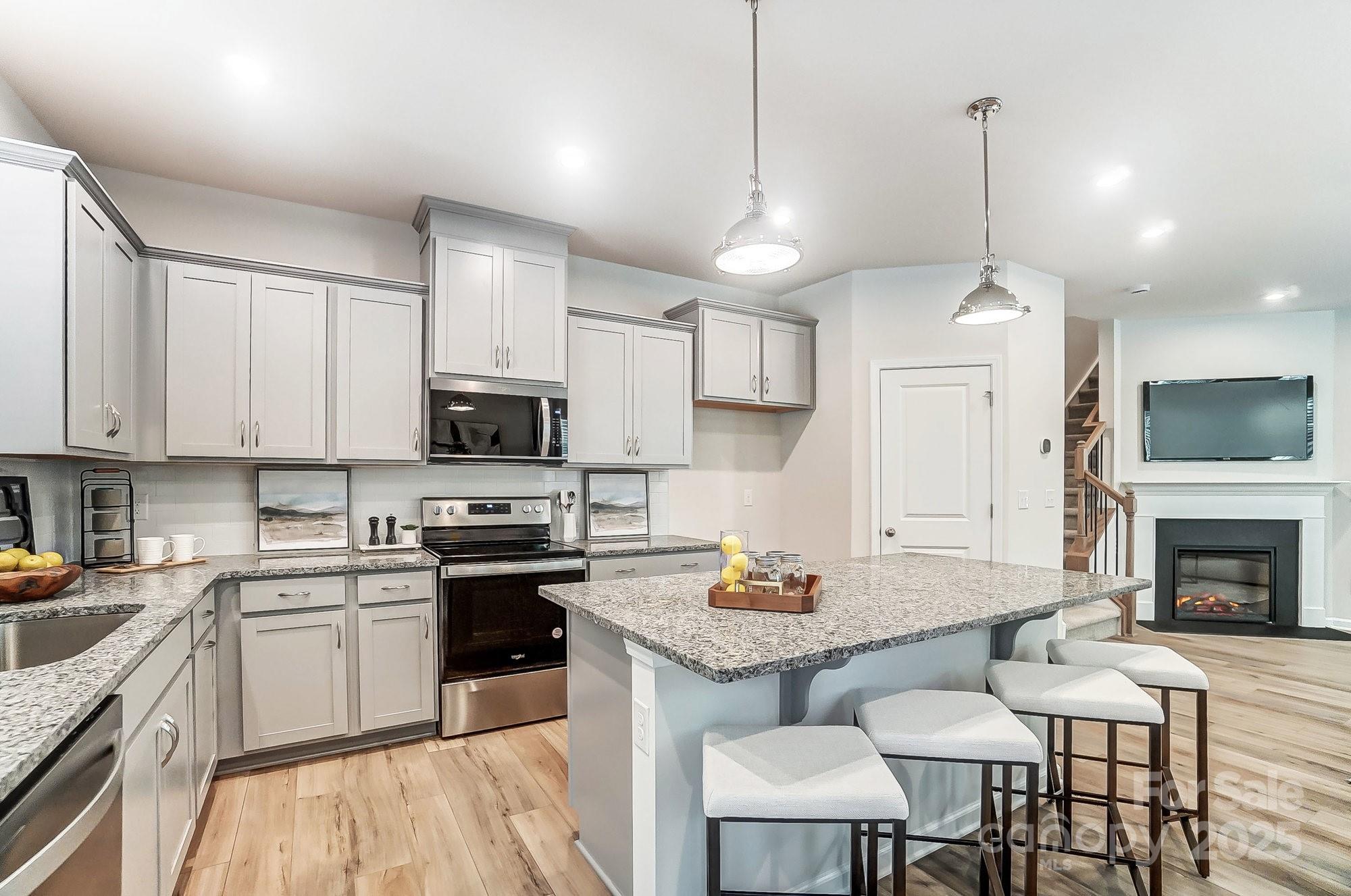 311 Laura Elizabeth Lane Clover, SC 29710 - Photo 13 of 39 a kitchen with granite countertop a stove a sink a dining table and chairs