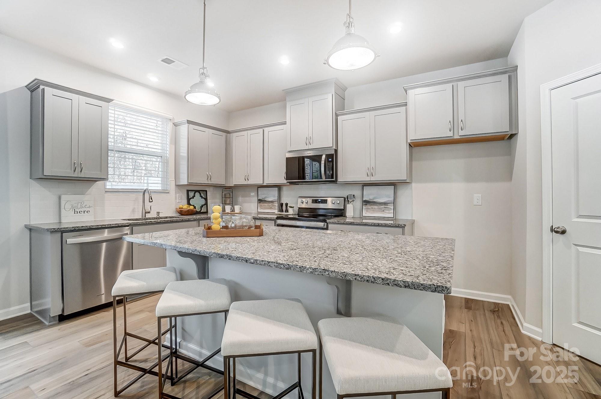 311 Laura Elizabeth Lane Clover, SC 29710 - Photo 7 of 39 a large kitchen with granite countertop lots of counter space white cabinets and stainless steel appliances