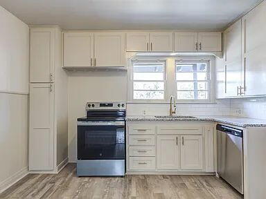 2716 29th Street Lubbock, TX 79410 - Photo 11 of 27 a kitchen with stainless steel appliances granite countertop a stove and a sink
