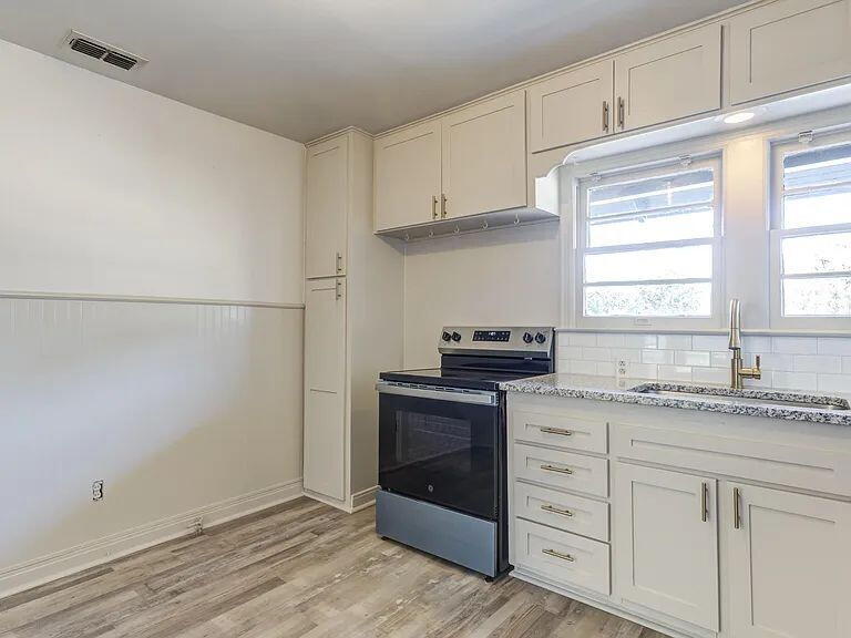 2716 29th Street Lubbock, TX 79410 - Photo 15 of 27 a kitchen with granite countertop white cabinets and white appliances