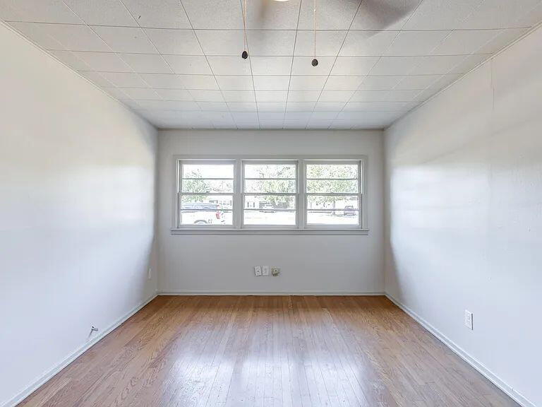 2716 29th Street Lubbock, TX 79410 - Photo 23 of 27 an empty room with wooden floor and windows
