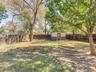 2716 29th Street Lubbock, TX 79410 - Photo 26 of 27 a backyard of a house with large trees and covered with tall trees
