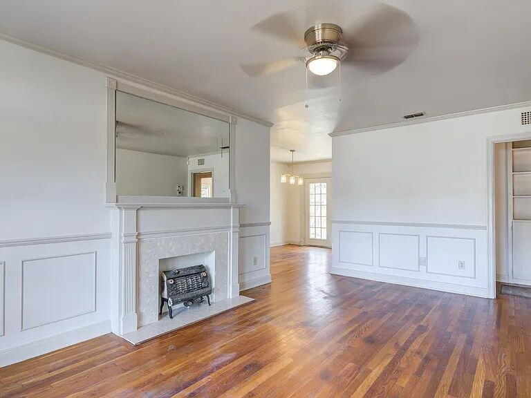 2716 29th Street Lubbock, TX 79410 - Photo 4 of 27 a view of an empty room with wooden floor and a fireplace