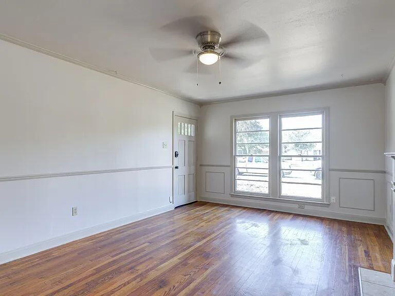 2716 29th Street Lubbock, TX 79410 - Photo 7 of 27 an empty room with wooden floor and windows