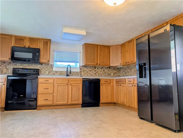 a kitchen with stainless steel appliances granite countertop a refrigerator a stove and a sink with wooden floor