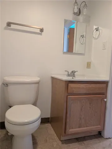 a bathroom with a toilet a sink and mirror