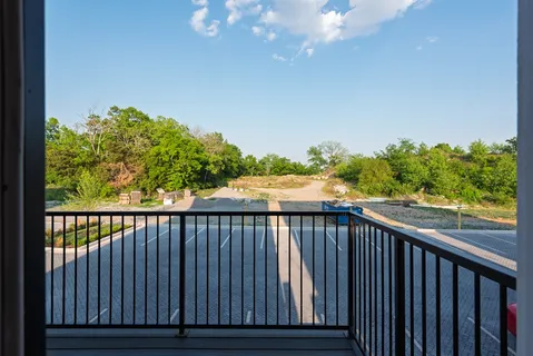 a view of a balcony with wooden floor and fence