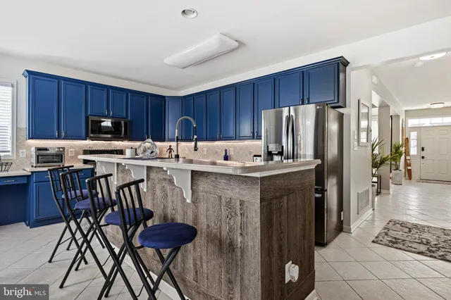 a kitchen with kitchen island granite countertop a sink dishwasher stove and cabinets with wooden floor