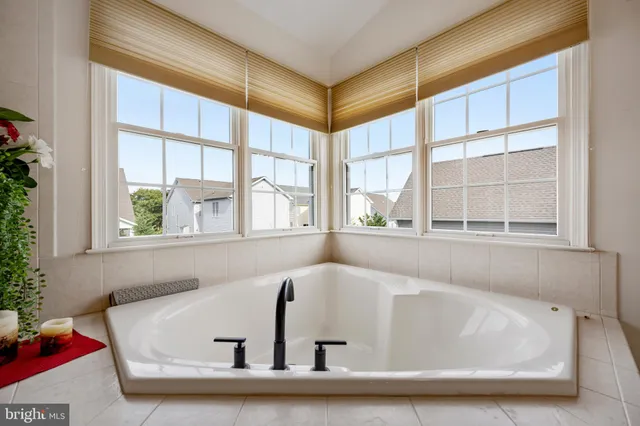 a bed sitting in a bedroom next to a window and a bathroom