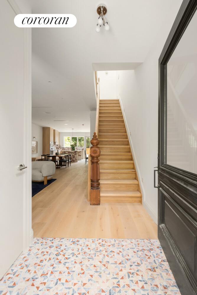 700 Monroe Street Brooklyn, NY 11221 - Photo 8 of 18 a view of a hallway to a livingroom with wooden floor and stairs