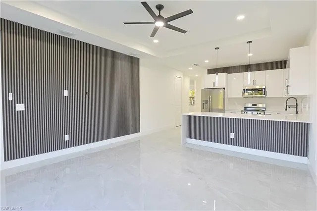 a kitchen with kitchen island a sink stainless steel appliances and cabinets