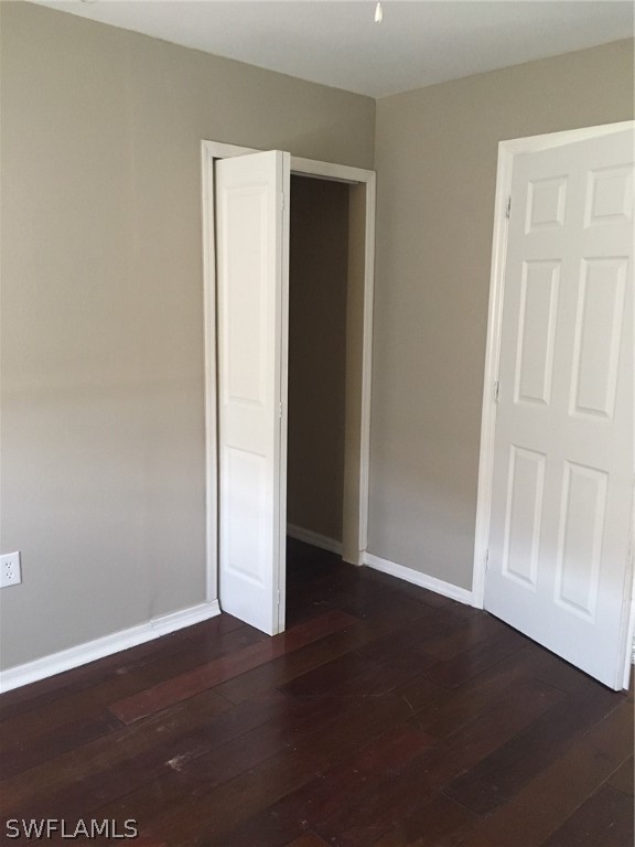 789 Alabama Road South Lehigh Acres, FL 33974 - Photo 30 of 30 an empty room with wooden floor and windows