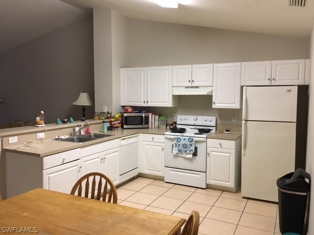789 Alabama Road South Lehigh Acres, FL 33974 - Photo 3 of 30 a kitchen with a white cabinets and white appliances