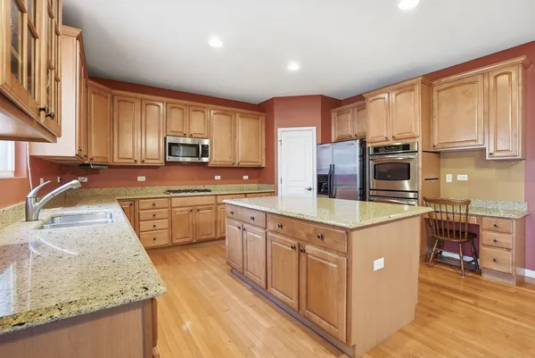 a kitchen with stainless steel appliances granite countertop a stove a sink and a microwave