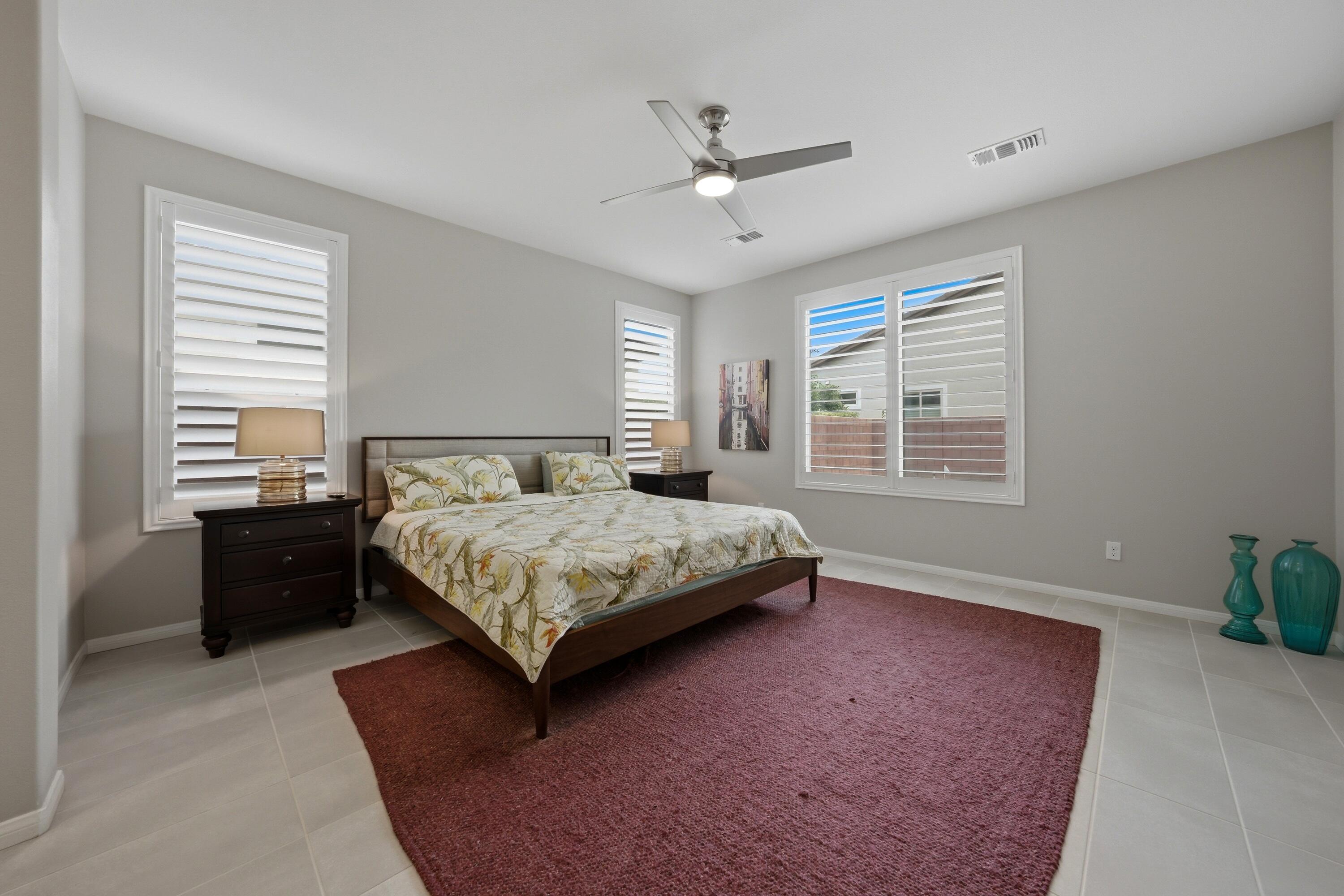51370 North Two Palms Way Indio, CA 92201 - Photo 13 of 37 a bedroom with a large bed and a chandelier