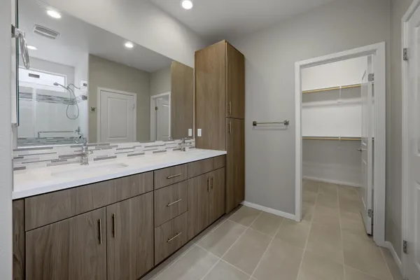 a bathroom with a double vanity sink mirror and shower