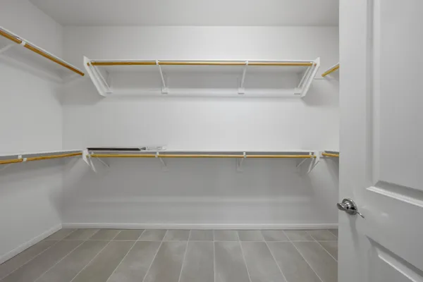 a view of walk in closet with empty racks