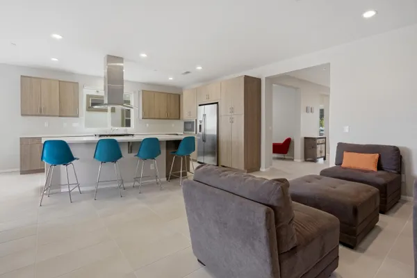 a living room with furniture and a view of kitchen