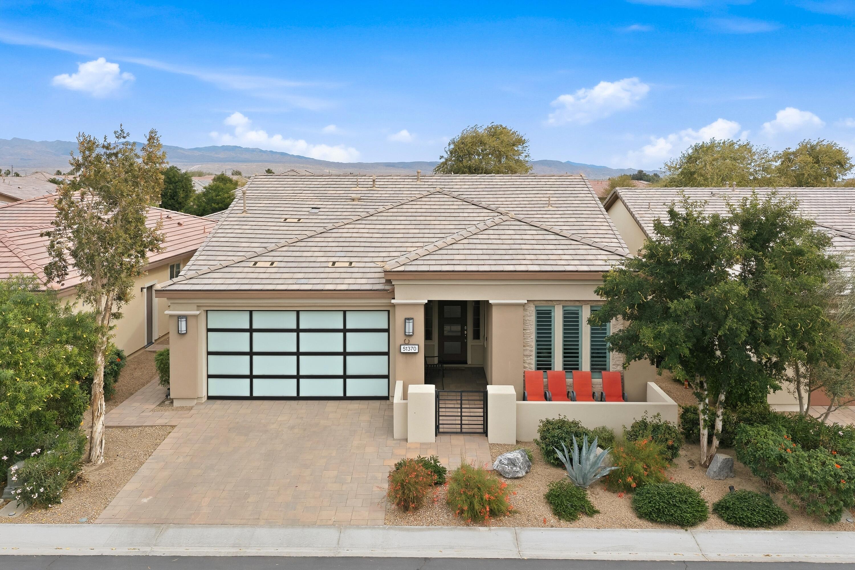 51370 North Two Palms Way Indio, CA 92201 - Photo 2 of 37 a view of a white house with a fountain and potted plants