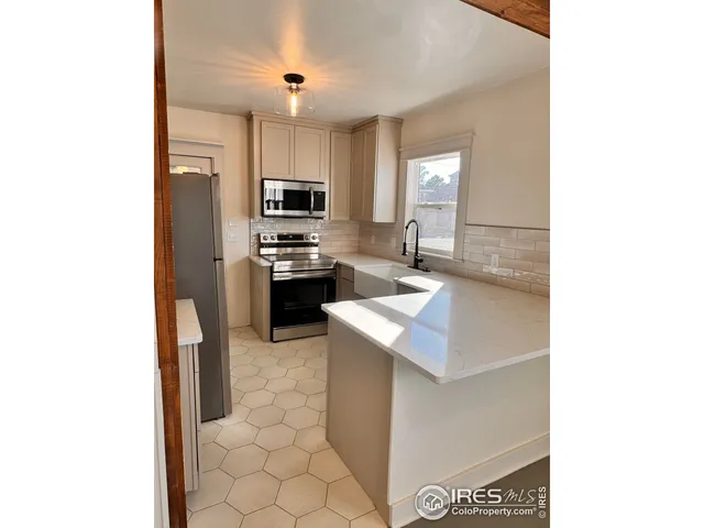 a kitchen with stainless steel appliances a sink stove and refrigerator