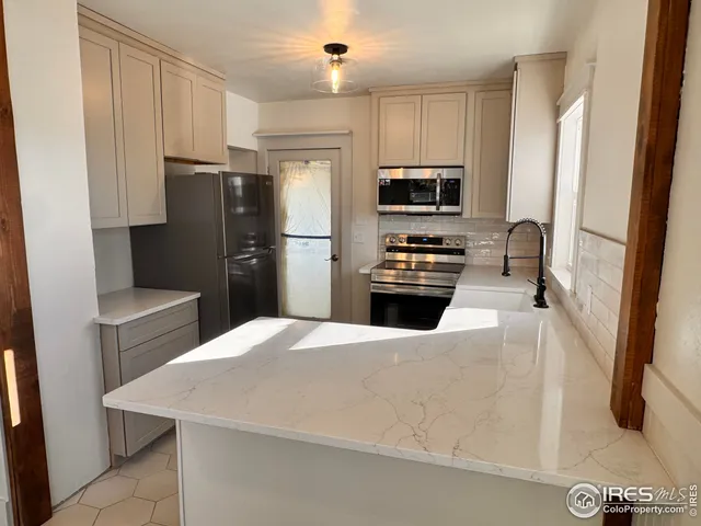 a kitchen with stainless steel appliances a refrigerator stove microwave and sink