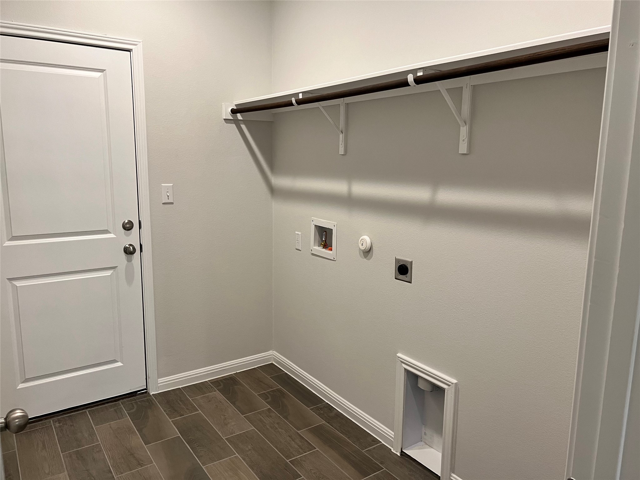 140 Pentro Path Georgetown, TX 78626 - Photo 14 of 37 A well-appointed utility room features durable wood-look tile flooring and a convenient clothes hanging rod.