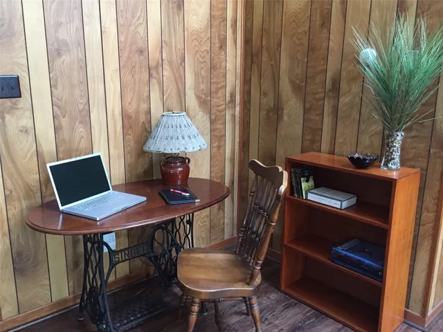 a view of a workspace with furniture and a window