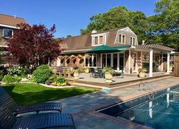 a front view of a house with yard and green space