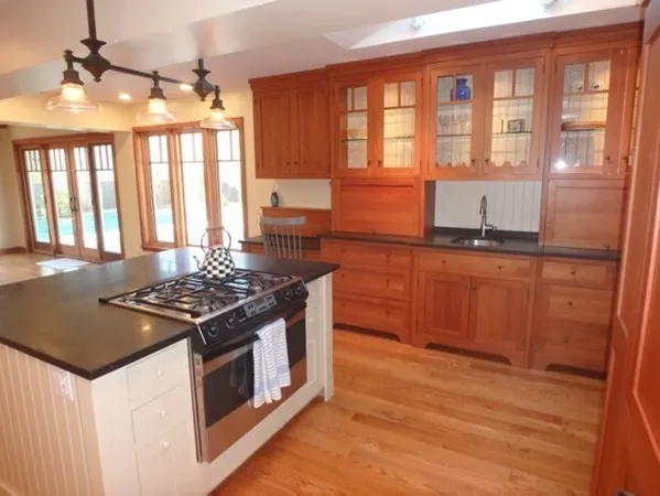 a kitchen with a stove and wooden floor