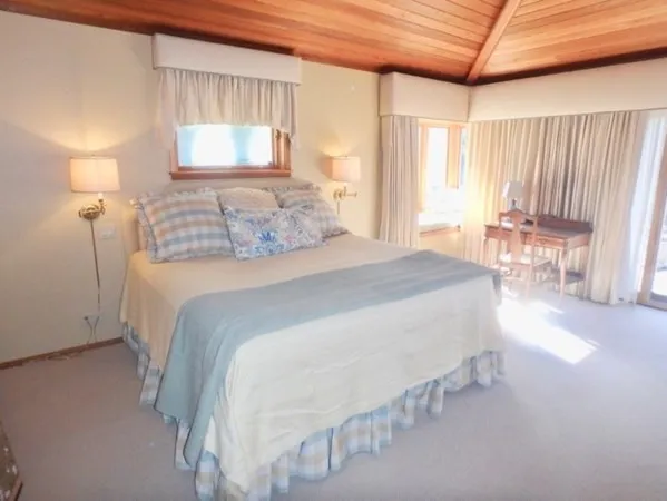 a bedroom with a bed and a table chair