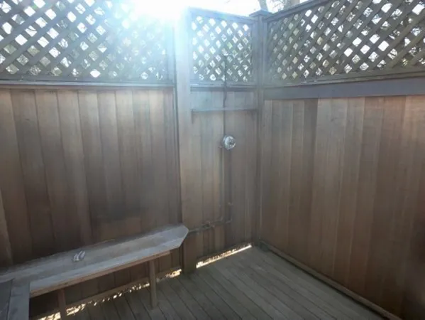 a wooden bench sitting in a bathroom near a shower