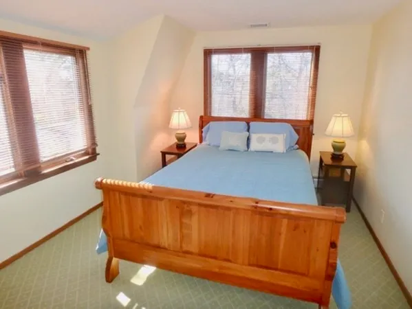 a bed sitting in a bedroom next to a window