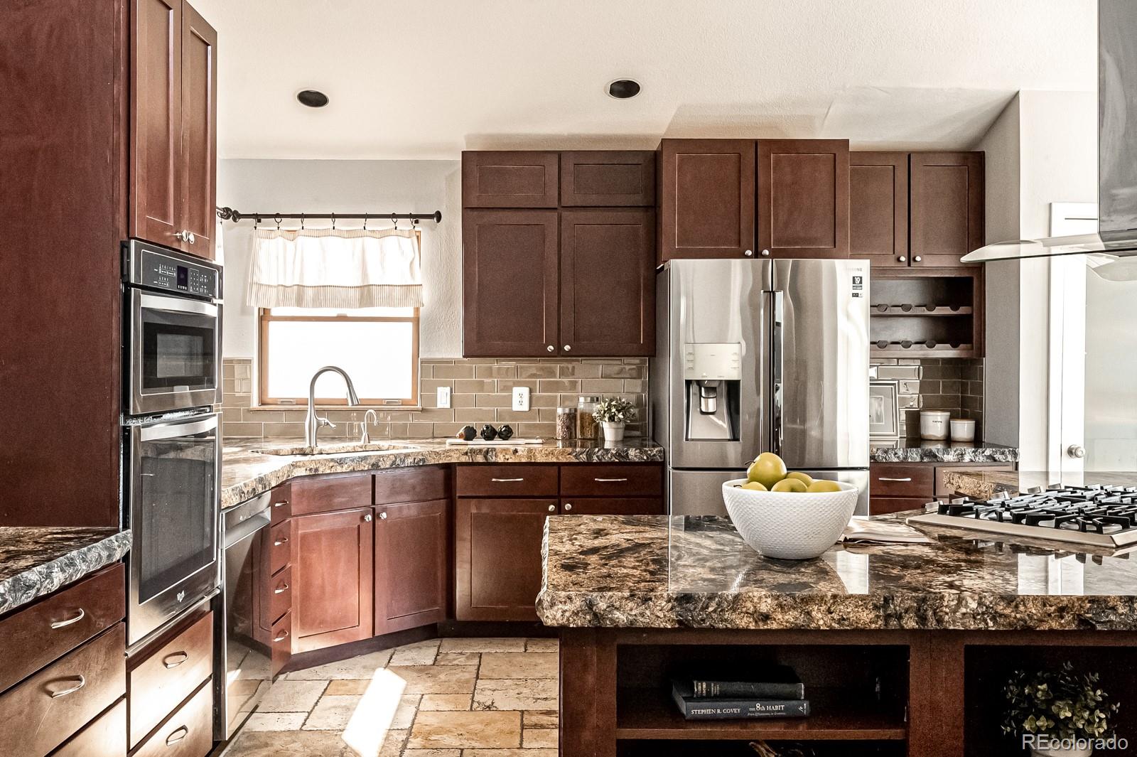 620 Cascade Drive Golden, CO 80403 - Photo 13 of 31 a kitchen with kitchen island granite countertop a stove a sink and a refrigerator