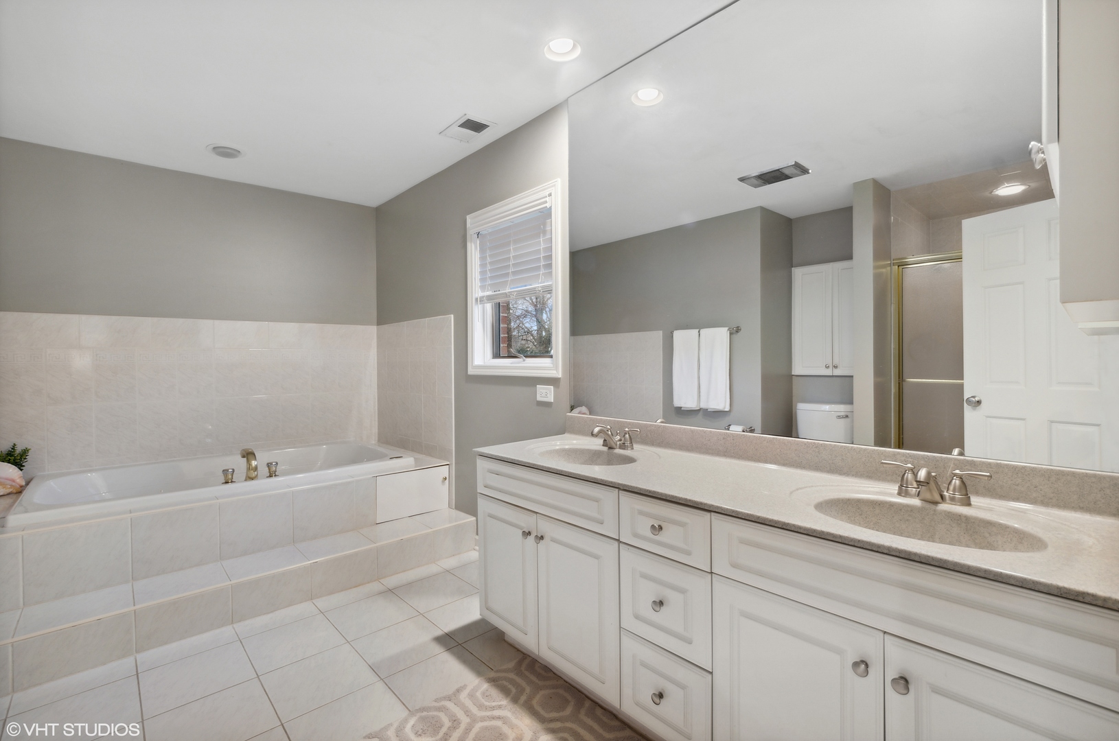 1041 Pontiac Road Wilmette, IL 60091 - Photo 16 of 33 a bathroom with a sink double vanity granite tub and a mirror