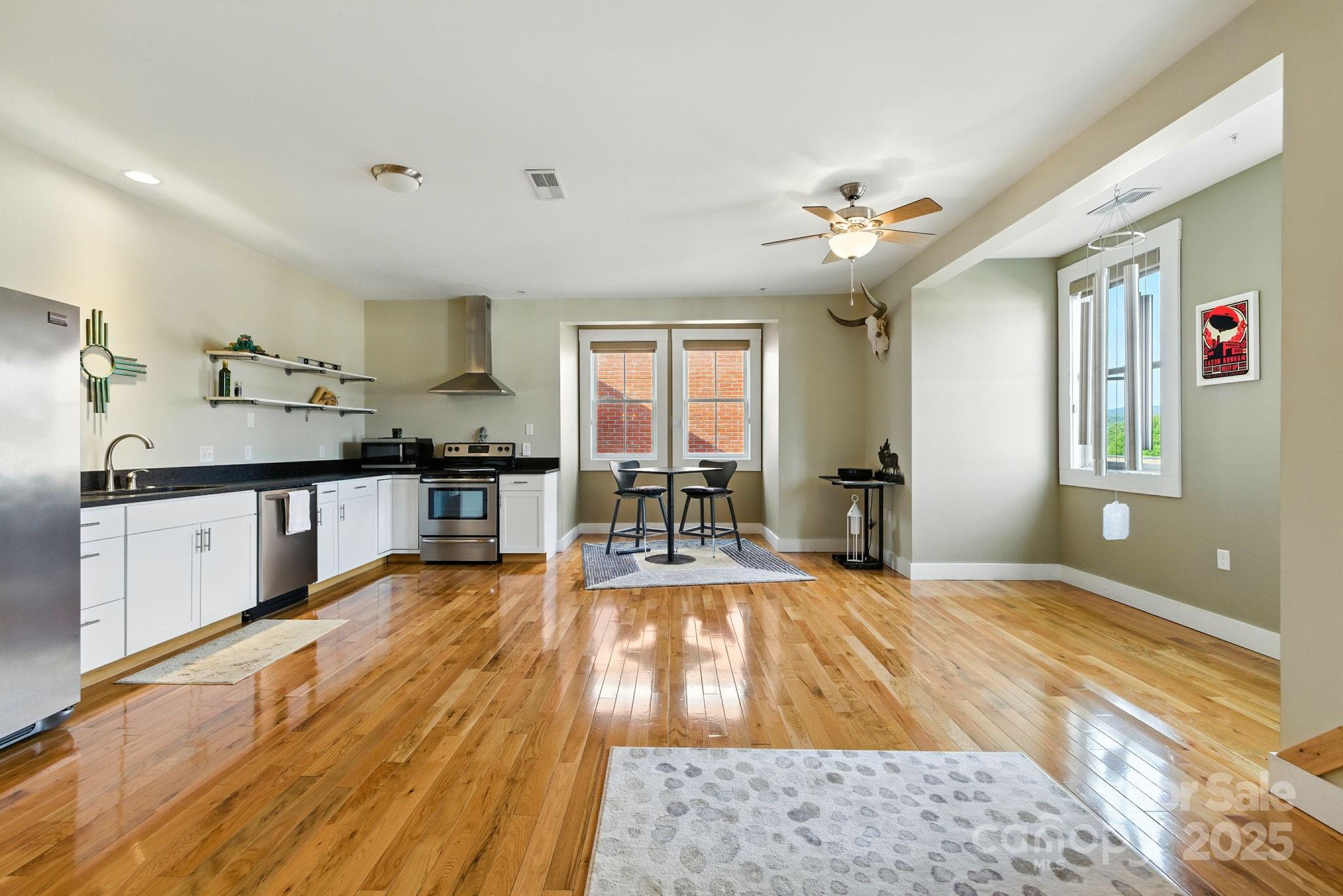 23 South Broad Street Brevard, NC 28712 - Photo 12 of 30 a large kitchen with kitchen island granite countertop a large window a sink and stainless steel appliances