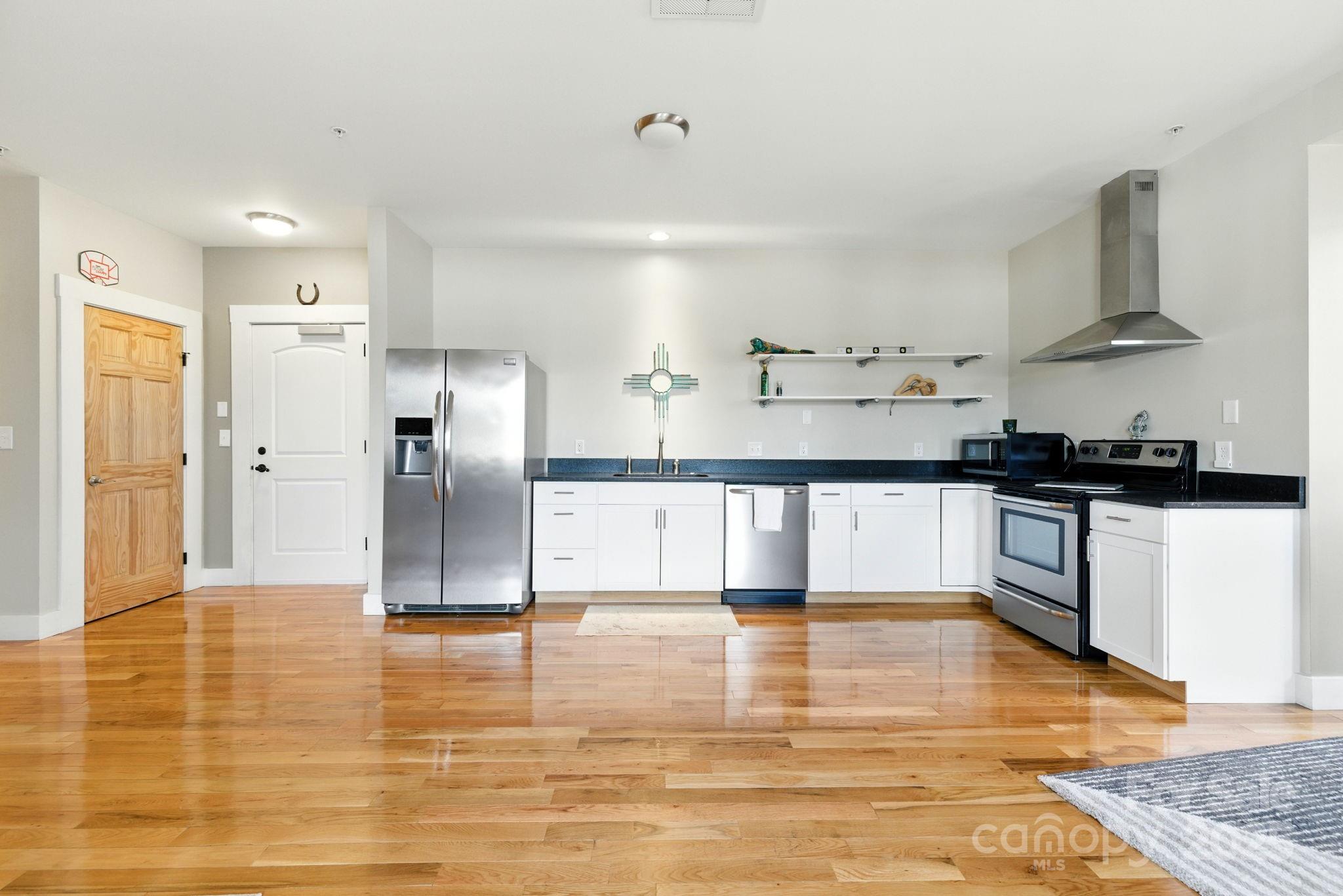 23 South Broad Street Brevard, NC 28712 - Photo 13 of 30 a large kitchen with cabinets and wooden floor