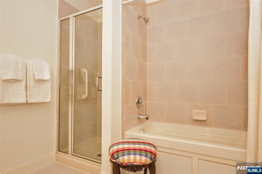 4201 Rio Vista Drive, Unit 4201 Mahwah, NJ 07430 - Photo 15 of 34 a bathroom with a granite countertop bathtub shower and a sink