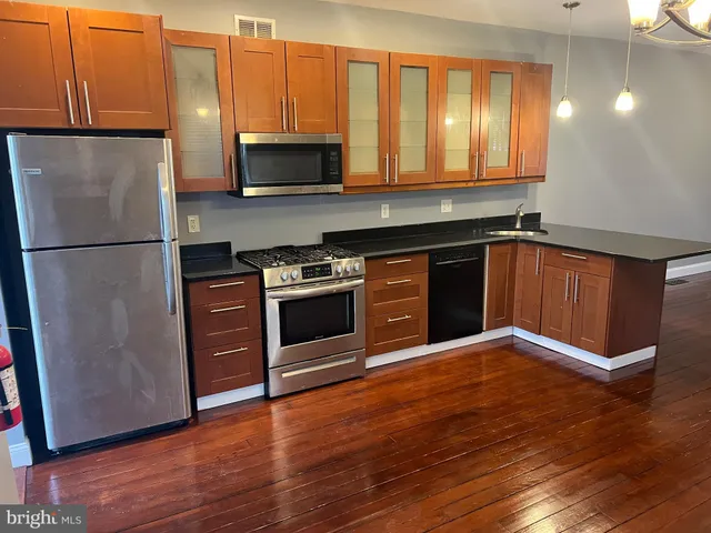 a kitchen with granite countertop wooden floors and stainless steel appliances