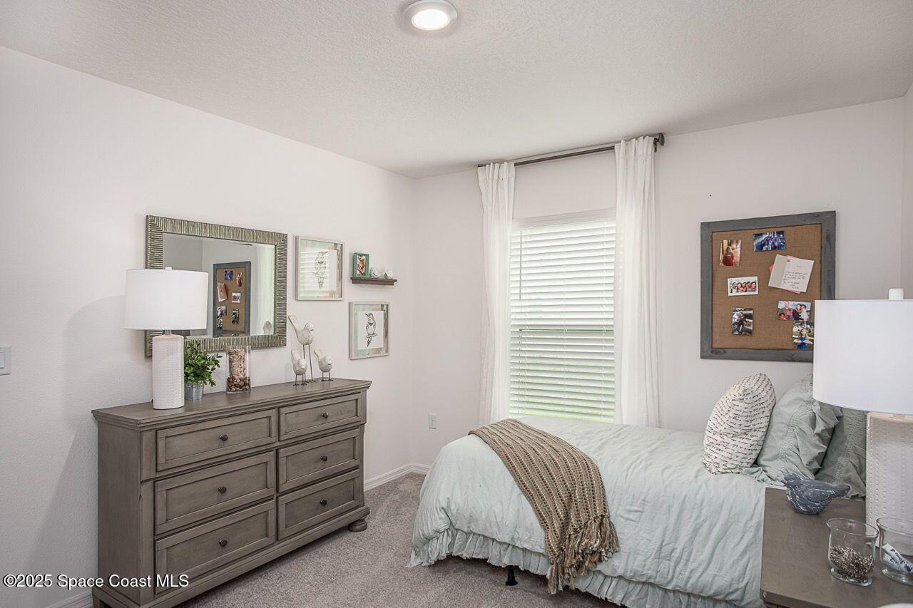 592 Plumbago Road Northwest Palm Bay, FL 32907 - Photo 13 of 20 a bedroom with a bed and a dresser in it