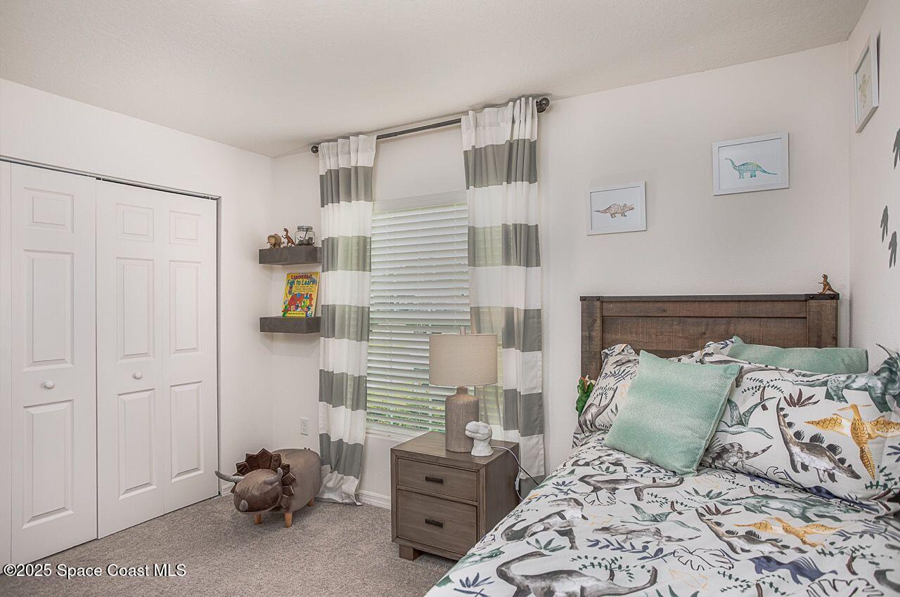 592 Plumbago Road Northwest Palm Bay, FL 32907 - Photo 14 of 20 a bedroom with a bed and a window