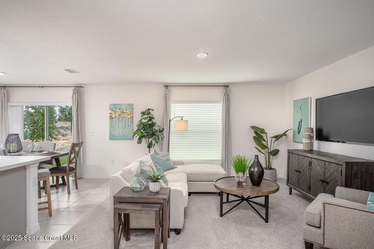 592 Plumbago Road Northwest Palm Bay, FL 32907 - Photo 8 of 20 a living room with furniture a flat screen tv and a large window